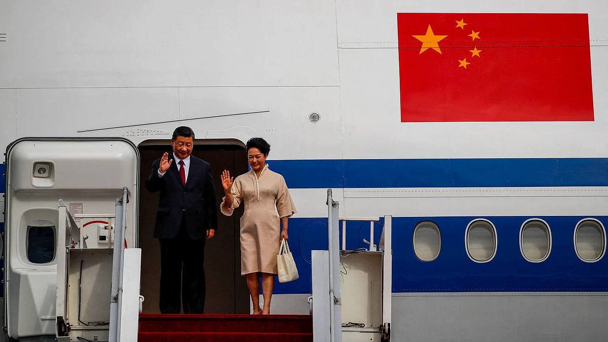 Chinese President Xi Jinping and his wife Peng Liyuan wave as they arrive at Ngurah Rai International airport in Bali on November 14. Photographer: Ajeng Dinar Ulfiana/AFP/Getty Images