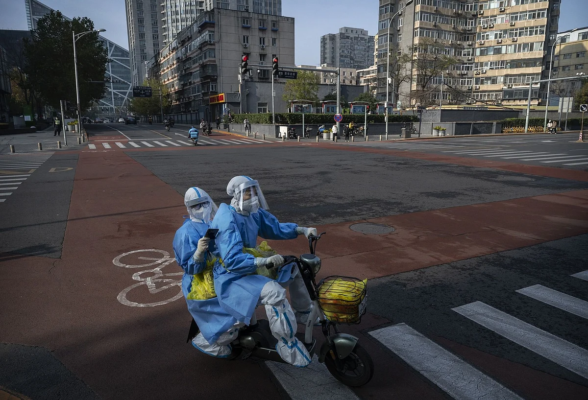 Epidemic control workers in a nearly empty street in Beijing on Nov. 23.