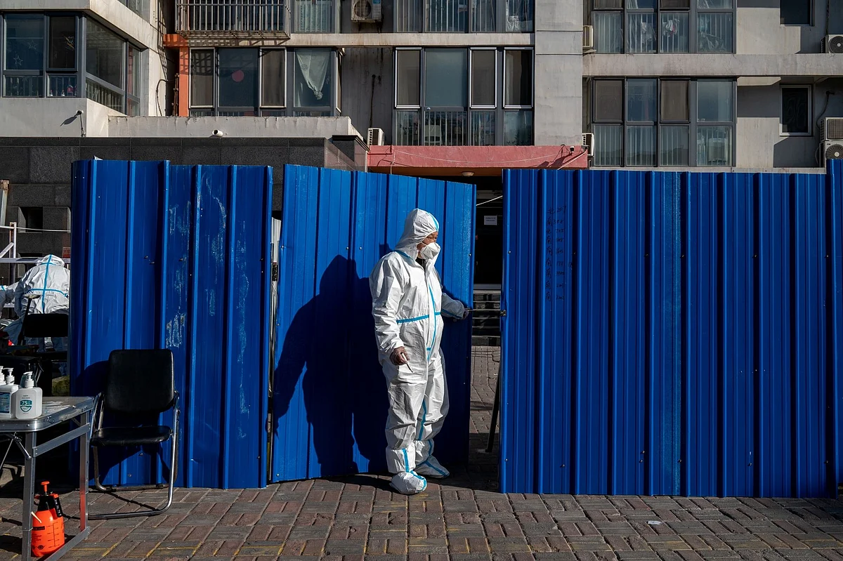 A worker in protective gear at a neighborhood placed under lockdown due to Covid-19 in Beijing, China, on Monday, Nov. 21, 2022. Surging infections are threatening to overwhelm some of the country’s biggest and most important cities, with local officials stymied over how to control the contagion without the usual tools of mass citywide testing and snap lockdowns. Bloomberg