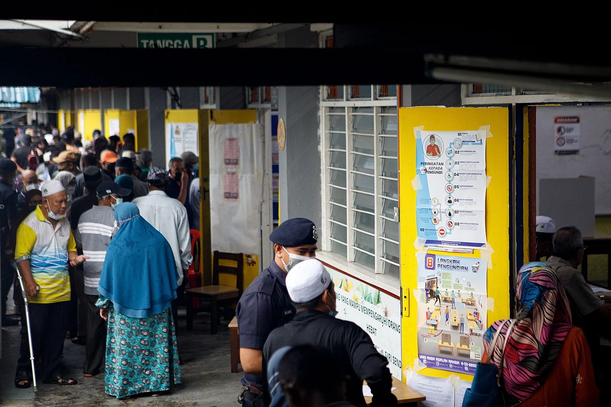 Voters stand in line at a polling station during a general election in Shah Alam, Selangor, Malaysia, on Saturday, Nov. 19, 2022. Malaysian voters began casting their ballots Saturday in an election where no one coalition is expected to clinch a parliamentary majority, prolonging instability in a country that has seen three governments in four years.