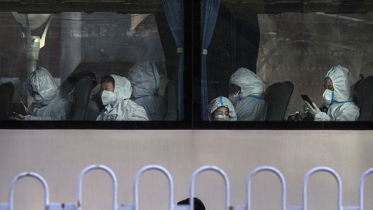 Passengers, including children, wear protective clothing inside a bus in Beijing on Nov. 15.