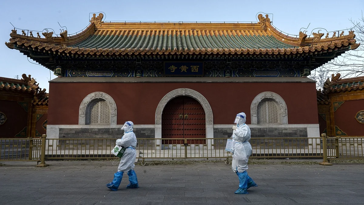 BEIJING, CHINA - DECEMBER 03: Epidemic control workers wear PPE as they walk by the Huangsi Temple on their way to perform nucleic acid tests on people under lockdown or health monitoring for COVID-19 on December 3, 2022 in Beijing, China. (Photo by Kevin Frayer/Getty Images) Photographer: Kevin Frayer/Getty Images AsiaPac