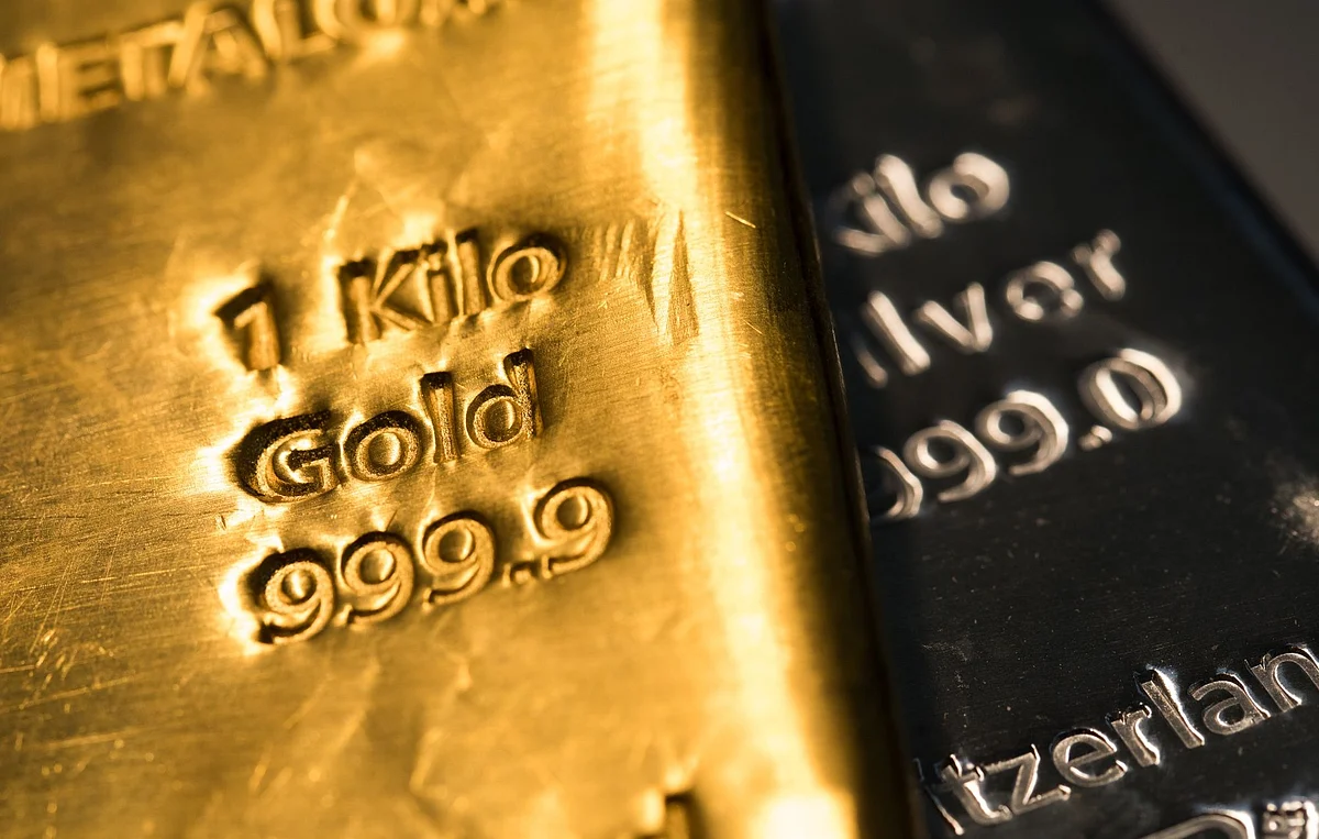 A one-kilogram gold bar sits on top of a one-kilogram silver bar at Gold Investments Ltd. bullion dealers in this arranged photograph in London, U.K., on Wednesday, July 29, 2020. Gold held its ground after a record-setting rally as investors awaited the outcome of a Federal Reserve meeting amid expectations policy makers will remain dovish, potentially spurring more gains. Photographer: Chris Ratcliffe/Bloomberg