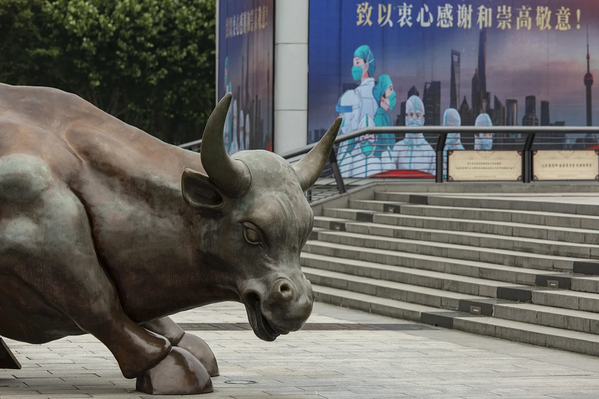 The Bund Bull statue and a screen displaying a thank you message for healthcare workers in Shanghai, China, on Wednesday, June 1, 2022. China's financial capital reported its fewest Covid-19 cases in almost three months as residents celebrated a significant easing of curbs on movement, while some companies took a more cautious approach, maintaining some restrictions in factories. Photographer: Qilai Shen/Bloomberg