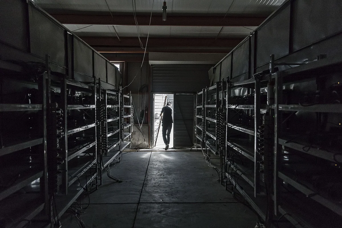 A technician exits a warehouse containing bitcoin mining machines at a mining facility operated by Bitmain Technologies Ltd. in Ordos, Inner Mongolia, China, on Friday, Aug. 11, 2017. Bitmain is one of the leading producers of bitcoin-mining equipment and also runs Antpool, a processing pool that combines individual miners from China and other countries, in addition to operating one of the largest digital currency mines in the world.