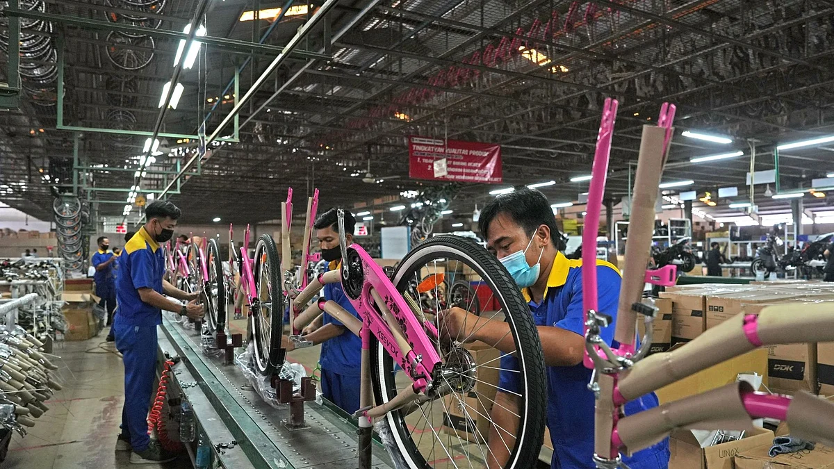 Workers labor on bicycles on the assembly line of PT. Terang Dunia Internusa's United Bike factory in Citeureup, West Java, Indonesia, on Thursday, Aug. 25, 2022. Countries around the world have set targets to reduce carbon emissions, and increasing the number of electric vehicles on the roads is key to meeting those goals. In Southeast Asia, where millions of people use motorbikes as their main form of transport, offering an electric option is key. Photographer: Dimas Ardian/Bloomberg