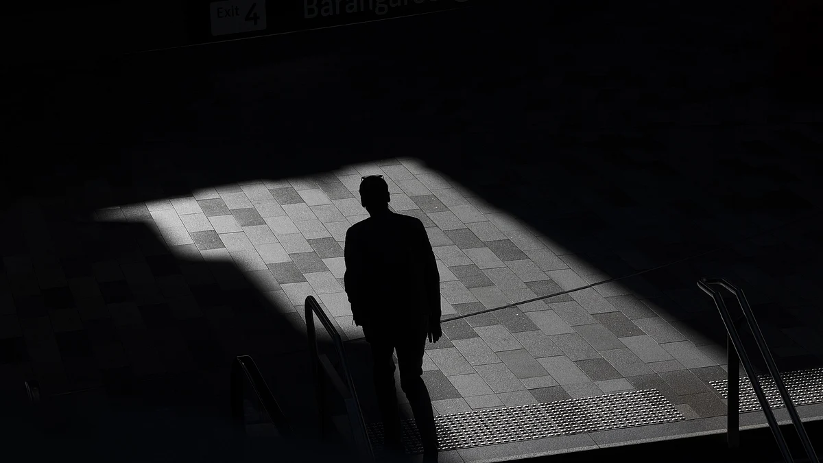 A silhouetted pedestrian outside a train station in Sydney, Australia, on Wednesday, Dec. 29, 2021. Hospitalizations due to coronavirus in Australia’s most-populous state have reached the highest level since mid-October, as a surge in omicron cases throughout most of the nation pressures the health system. Photographer: Brent Lewin/Bloomberg