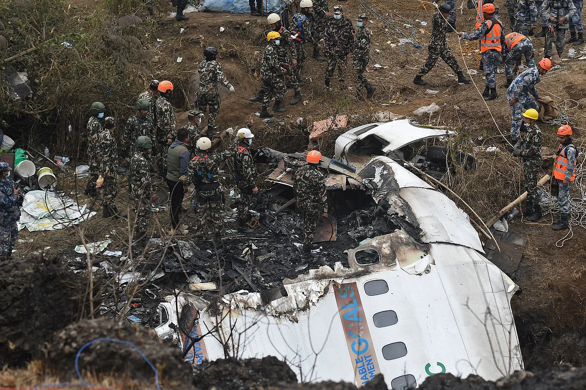 Rescue workers inspect wreckage at the site of a Yeti Airlines crash in Pokhara, Nepal. Photographer: Prakash Methema/AFP/Getty Images
