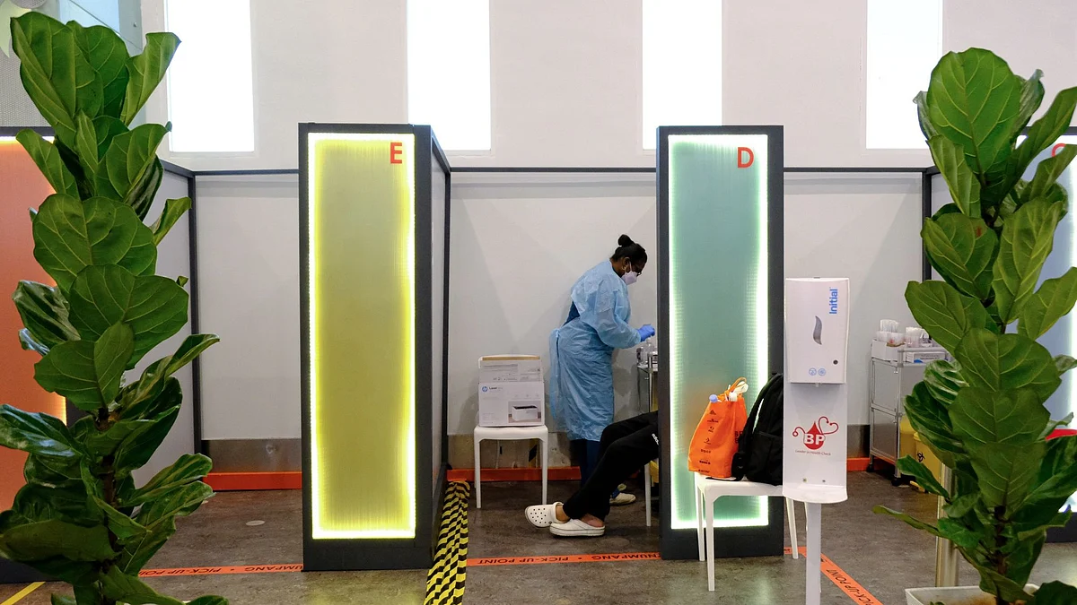 A health worker at a Covid-19 screening center at Kuala Lumpur International Airport 2 (KLIA 2) in Sepang, Selangor, Malaysia, on Friday, April 1, 2022. Malaysia allows quarantine-free entry for fully vaccinated travelers from April 1, ending almost two years of stringent border controls introduced to contain the Covid-19 outbreak. Photographer: Samsul Said/Bloomberg