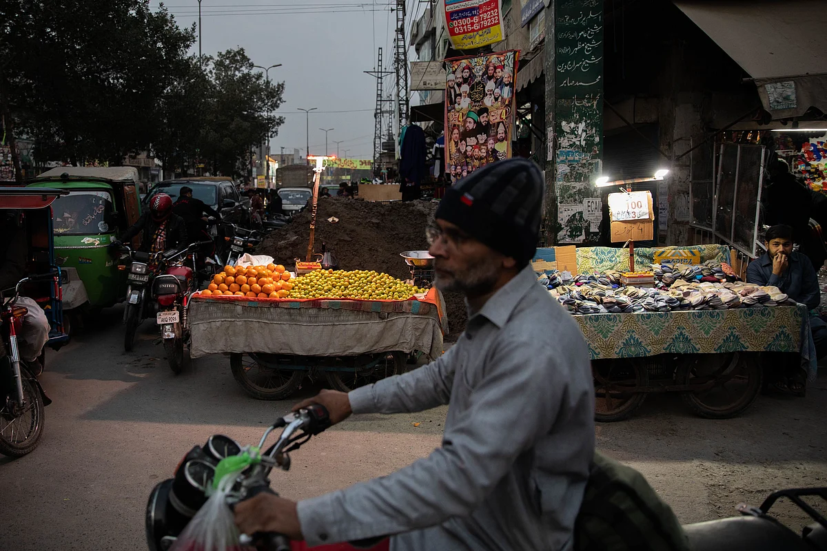 Vendors sell fruit under lights lit by batteries in Lahore. Photographer: Betsy Joles/Bloomberg