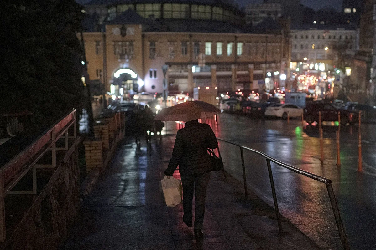 A shopper walks along a road at night in Kyiv, Ukraine, on Thursday, Jan. 5, 2023.