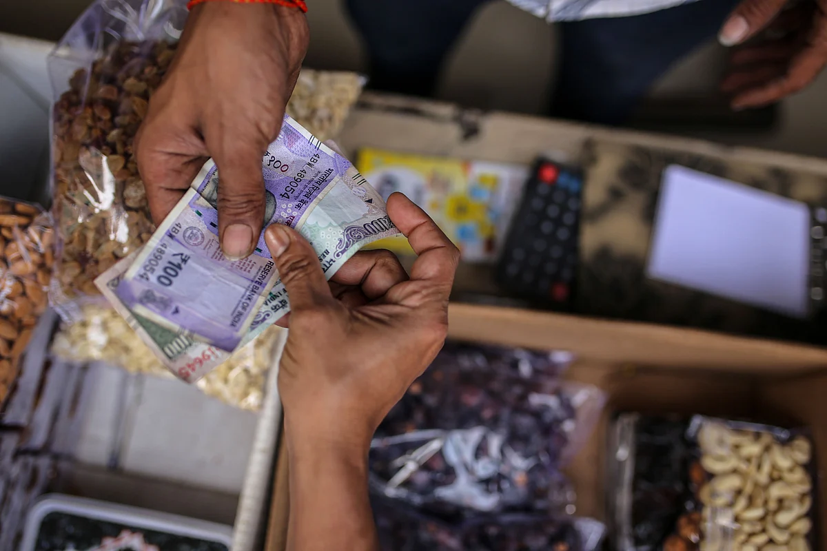 Customers holds rupee banknotes at a grocery store in Mumbai, India, on Saturday, Jan. 7, 2023. India is scheduled to release consumer price index (CPI) figures on Jan. 12. Photographer: Dhiraj Singh/Bloomberg