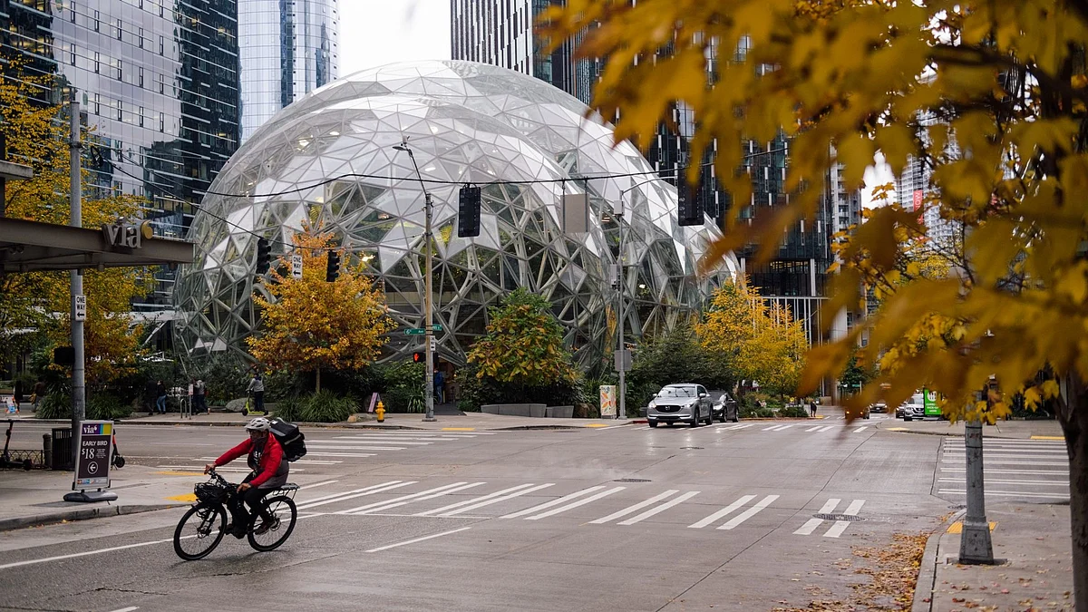 A delivery worker travels past the Amazon Spheres, part of the Amazon headquarters campus, in the South Lake Union neighborhood of Seattle, Washington, U.S., on Friday, Oct. 22, 2021. Concerns about Covid, crime and homelessness — and open warfare between the city government and parts of its lucrative tech and business sector — have emptied Seattle's commercial districts. Voters are hoping a new mayor will turn things around — but even though most are Democrats, they disagree on what change is needed.
