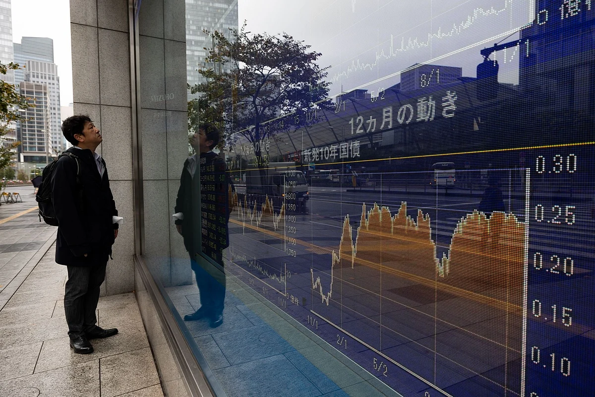 An electronic stock board outside a securities firm in Tokyo, Japan, on Monday, Nov. 21, 2022. The world's central banks must keep raising interest rates to fight soaring and pervasive inflation, even as the global economy sinks into a significant slowdown, the OECD said. Photographer: SeongJoon Cho/Bloomberg