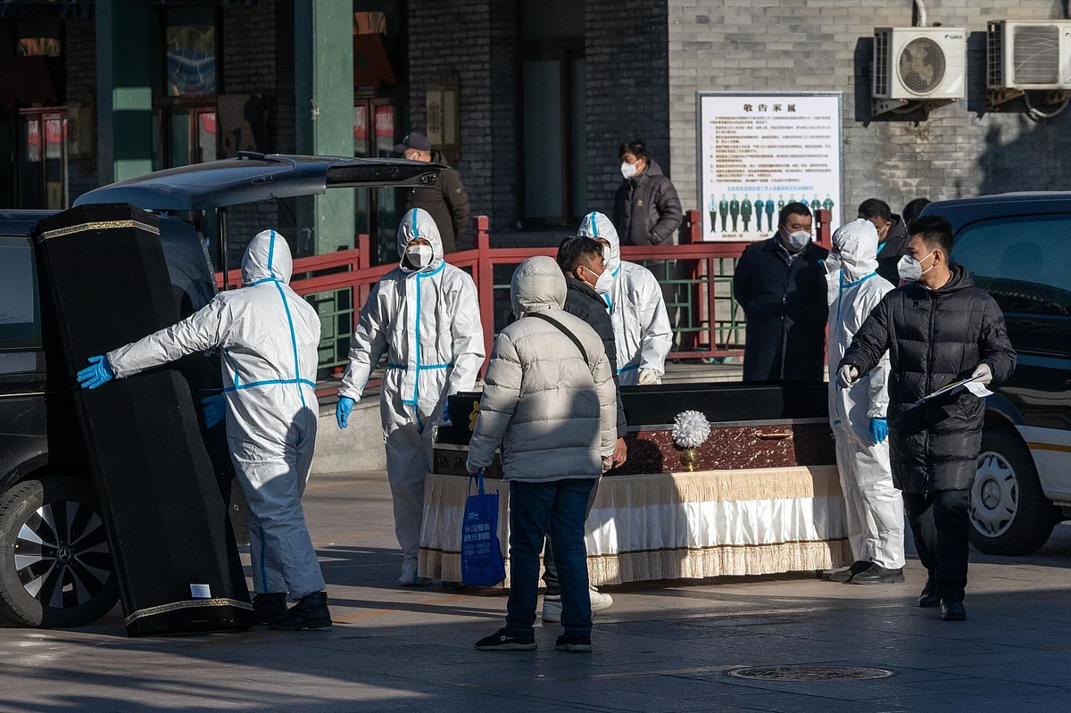 Workers in protective gear handle a coffin and coffin case at Dongjiao Funeral Parlor, reportedly designated to handle Covid fatalities, in Beijing, on Dec. 19.