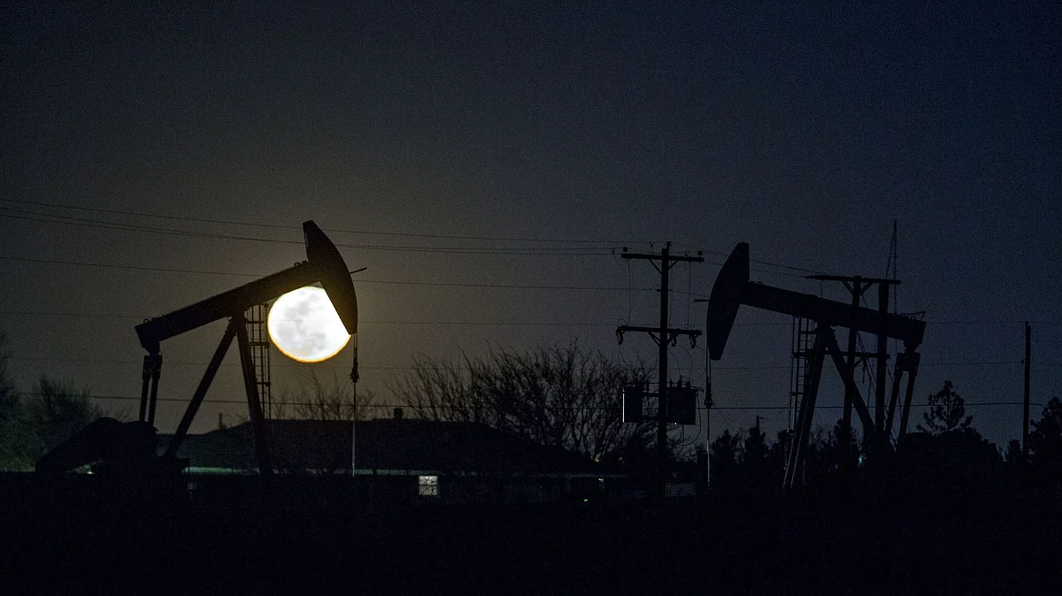 The silhouette of oil pump jacks are seen as the moon rises in Texas, U.S. Photographer: Bloomberg Creative Photos/Bloomberg