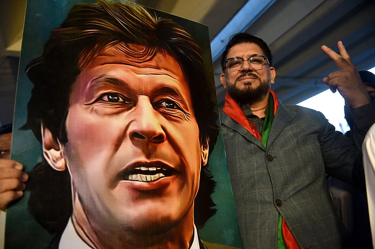 A supporter of Pakistan's former prime minister Imran Khan, gestures while holding Khan's portrait during a protest against the assassination attempt on him, in Karachi on November 6, 2022. Photographer: Rizwan Tabassum/AFP/Getty Images