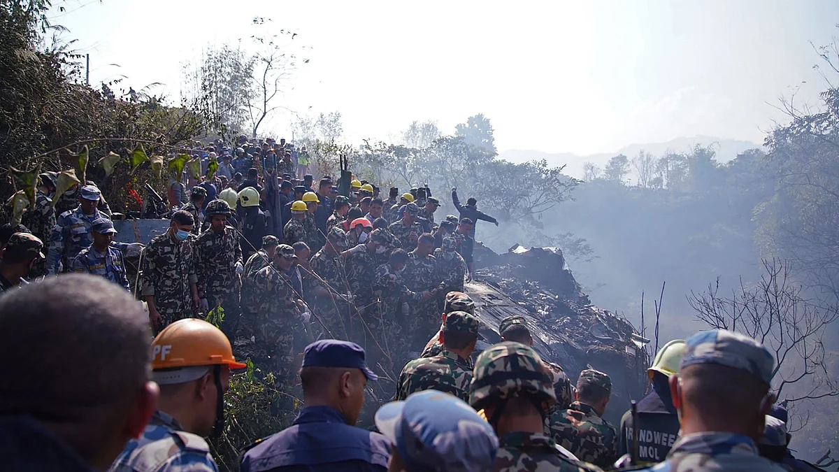 Rescuers gather at the site of a plane crash in Pokhara on Jan. 15. Photographer: Yunish Gurung/AFP/Getty Images