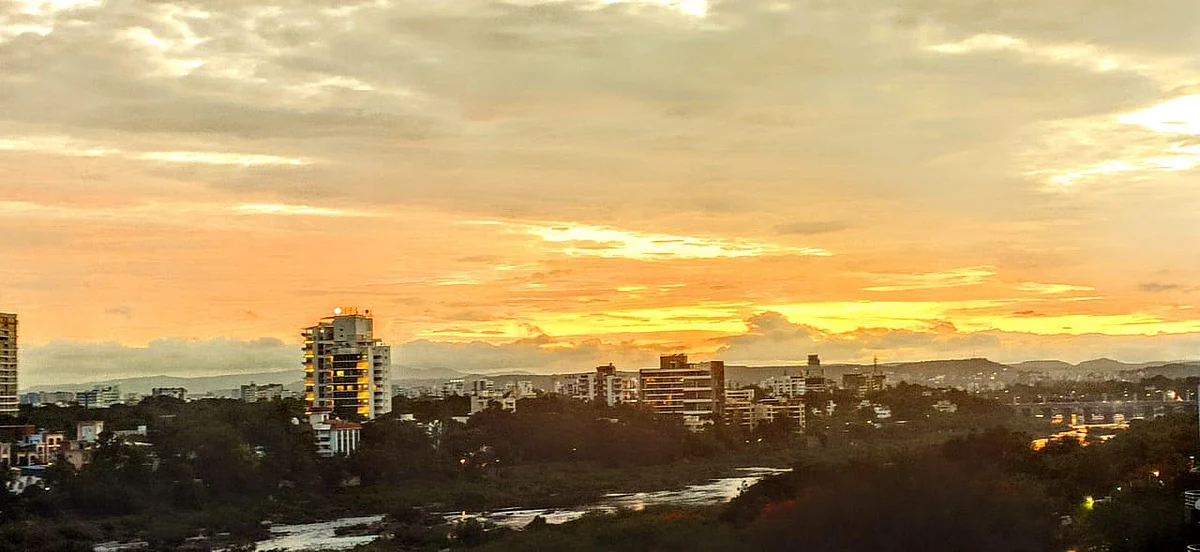 The spectacular setting sun lights up the sky and the sliver of river