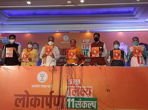 Finance Minister Nirmala Sitharaman, along with party leaders, presents the BJP’s manifesto for Bihar. It promises free COVID-19 vaccine for all in the state. Photo: Twitter / @bjp4bihar 