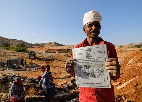 A man working under the Mahatma Gandhi National Rural Employment Guarantee Scheme displays his job card in Rajasthan’s Dungarpur district.