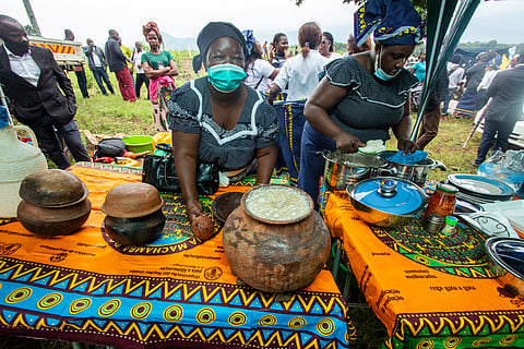 Women in Mozambique selling traditional African millet beer known as umqombothi, pombe, chibuku, or cambanga, served in clay vessels called ukhamba and poured into calabash mugs.