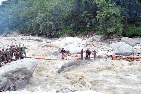 Security personnel constructing a makeshift bridge in flood-hit Uttarakhand. 