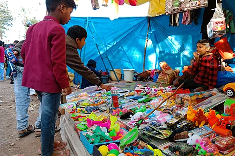 भारत में प्लास्टिक से बने खिलौनों को निहारते बच्चे; फोटो: आईस्टॉक