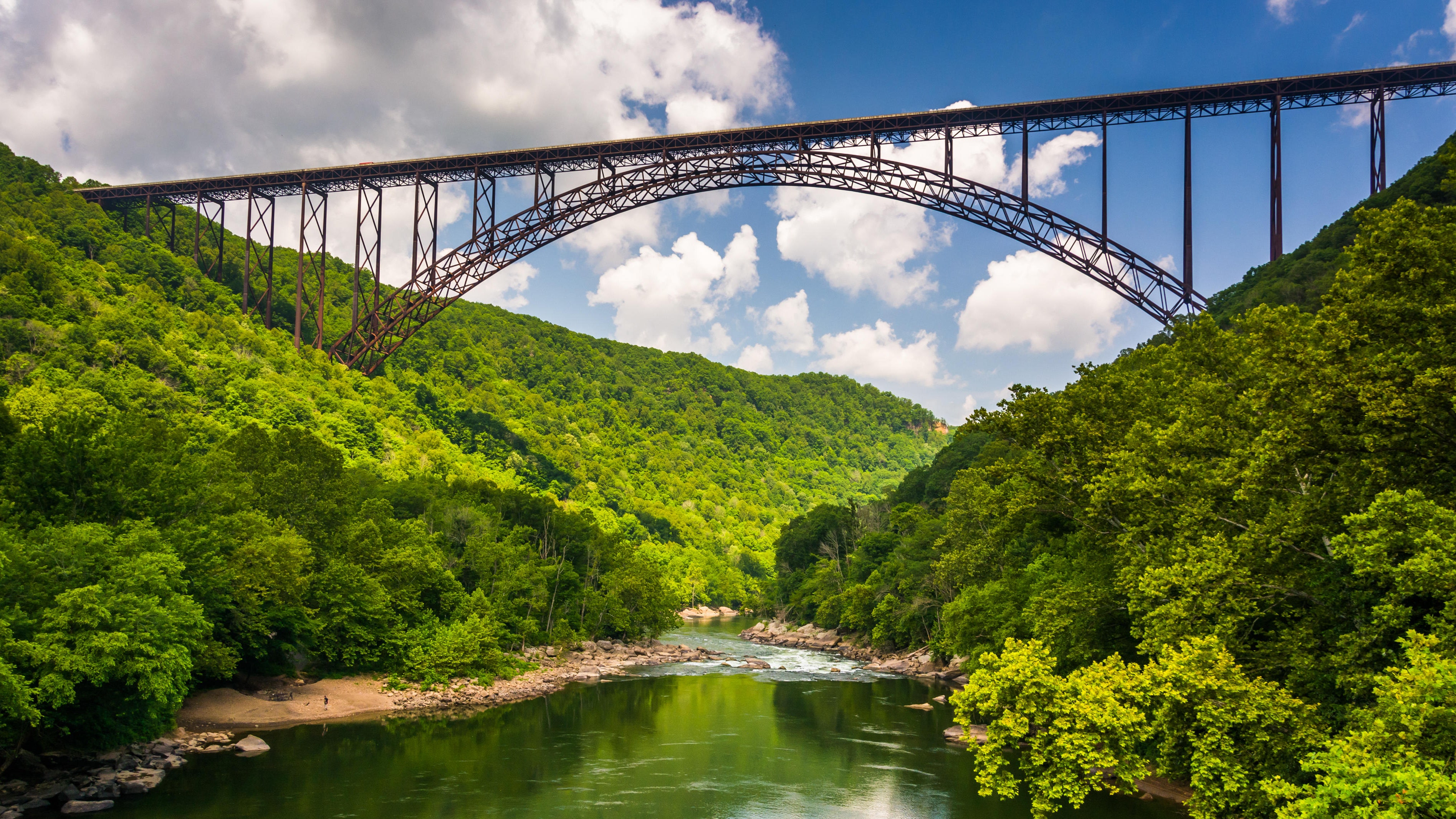 न्यू रिव्हर गॉर्ज, वेस्ट व्हर्जिनिया (The New River Gorge, West Virginia) -
दक्षिण पश्चिम व्हर्जिनियाच्या मध्यभागी स्थित, एक लपलेले रत्न, आणि या सुट्टीसाठी एक परिपूर्ण गेटवे म्हणजे न्यू रिव्हर गॉर्ज नॅशनल पार्क अँड प्रिझर्व्ह. हा एक संरक्षित जलमार्ग आहे जो ८५ किलोमीटरपर्यंत मूळ पर्वतीय घाटातून आश्चर्यकारकरित्या पसरलेला आहे. येथे आजूबाजूच्या प्रदेशाची चित्तथरारक दृश्ये तुम्हाला मोहून टाकतील. न्यू रिव्हर गॉर्ज ब्रिजचे दृश्य पाहण्यासाठी सोबतच राज्यातील सर्वात जास्त छायाचित्रित खुणांपैकी एक, दरीच्या अर्ध्या मार्गावर जा. व्हाईट-वॉटर राफ्टिंगसाठी न्यू रिव्हर हे यूएस मधील सर्वोत्तम ठिकाण आहे आणि येथे उत्कृष्ट राफ्टिंग, पॅडल बोर्डिंग, घोडेस्वारी, बोल्डरिंग, रॅपलिंग, हायकिंग आणि स्नोशूइंग देखील करता येते. ख्रिसमसच्या गजबजलेल्या पार्ट्या आणि गर्दीपासून दूर शांतता शोधणाऱ्या सर्वांसाठी हे योग्य ठिकाण आहे.