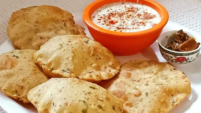 3) पुरी (Puri)
साहित्य
- कणीक-चार वाट्या
- हरभरा डाळीचे पीठ- एक चमचा
- तेल अर्धी वाटी
- मीठ चवीपुरते
- साखर अर्धा चमचा
- पाणी
कृती
- कणकेमध्ये चवीनुसार मीठ, साखर, तेल, हरभरा डाळीचे पीठ घालून पाण्याने कणीक घट्ट भिजवा.
- थोड्या वेळाने कणीक चांगली मळून त्याच्या छोट्या- छोट्या गोळे करुन लाटा आणि तळून घ्या.