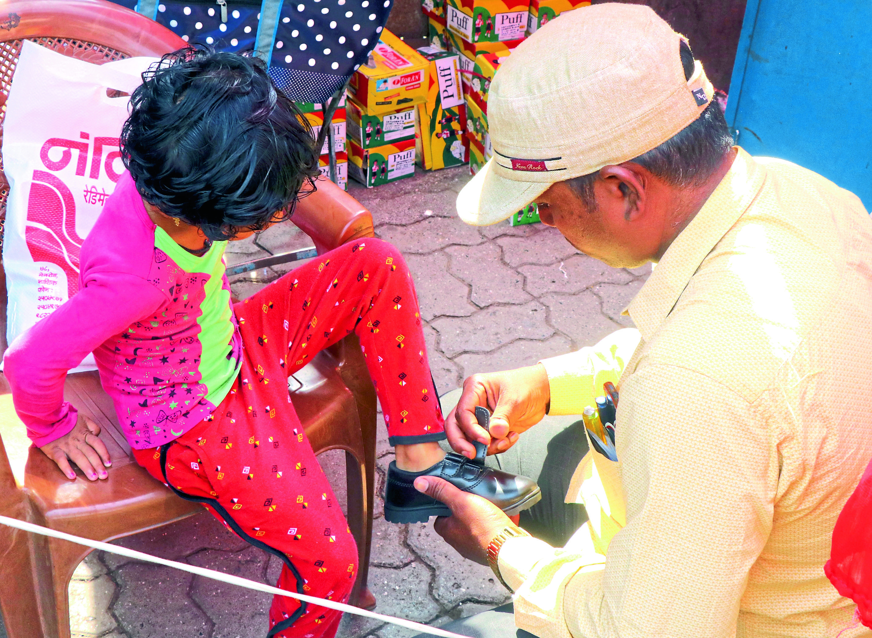 आपल्या पाल्यासाठी बूट घेण्यात मग्न पालक