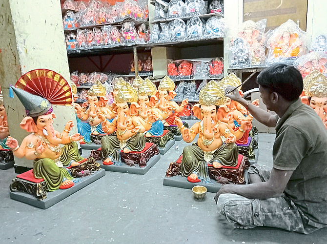Sculptors putting final touches on finished Ganesha idols.
