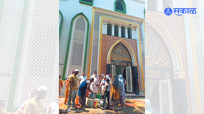 A cleric distributing water from Noorani Masjid