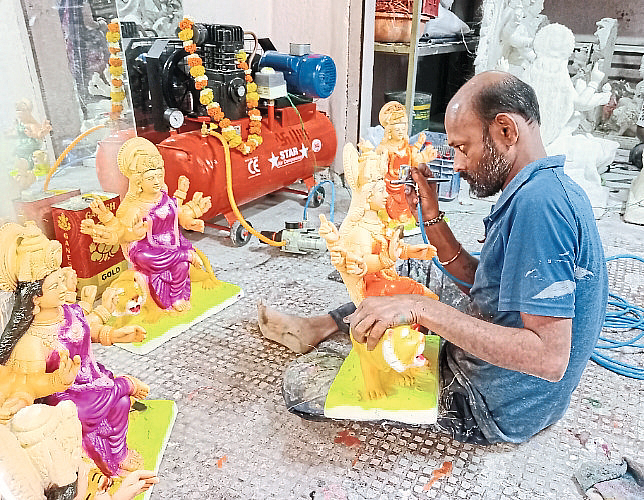 An artisan engaged in the work of making an idol of a goddess.