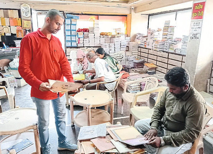 Consumers while choosing wedding cards from different types of albums.