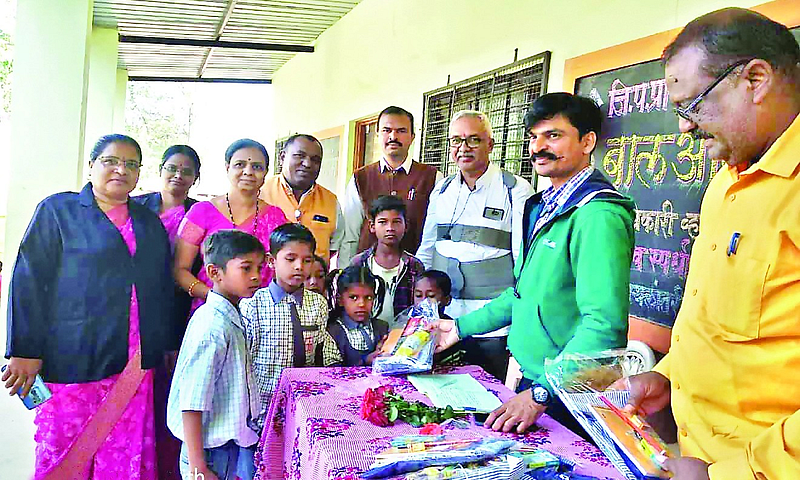 Group Education Officer Nilesh Patil giving school materials to migrant students at the brick kiln here
