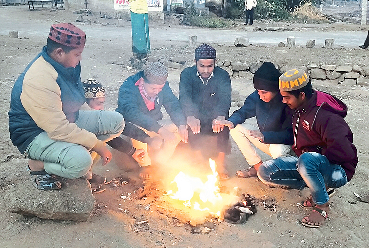 There is a picture of bonfires burning at the intersections in the city as the temperature drops.