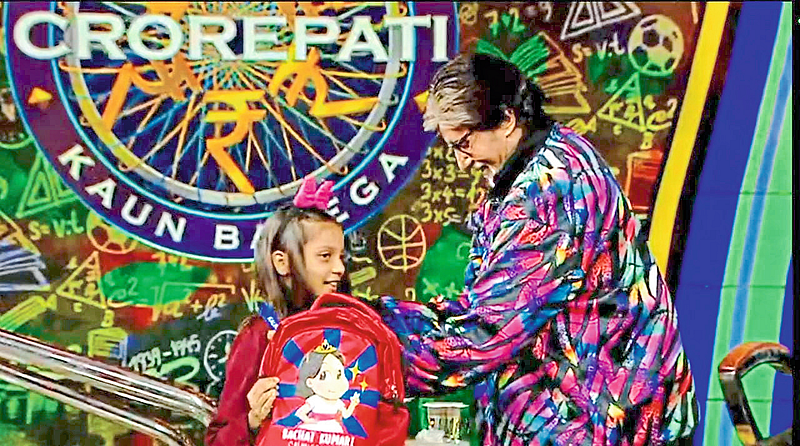 Megastar Amitabh Bachchan felicitating Surbhi Tripathi, a participant in the 'Kaun Banega Crorepati' program, with a gift.