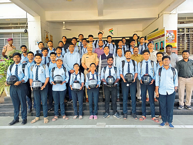 Jalgaon: RTO Shyam Lohi while distributing helmets to students in Government Engineering College. Neighbor Principal Dr. G. M. Malwatkar etc