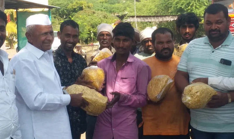 Vitthalrao Shinde Co-operative Sugar Factory Senior Director, Wamanrao Ubale, distributed Faral to sugarcane harvesters.jpg