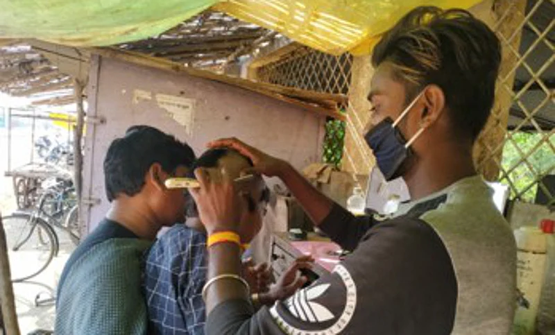 गडचिरोली : केशकर्तनालयात बालकाचे टक्कल करताना कारागीर.