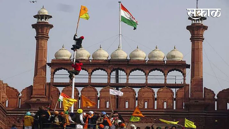 नवी दिल्ली: आंदोलक शेतकऱ्याने मंगळवारी लाल किल्ल्यावर शिखांचा पिवळा आणि केशरी झेंडा फडकवला.