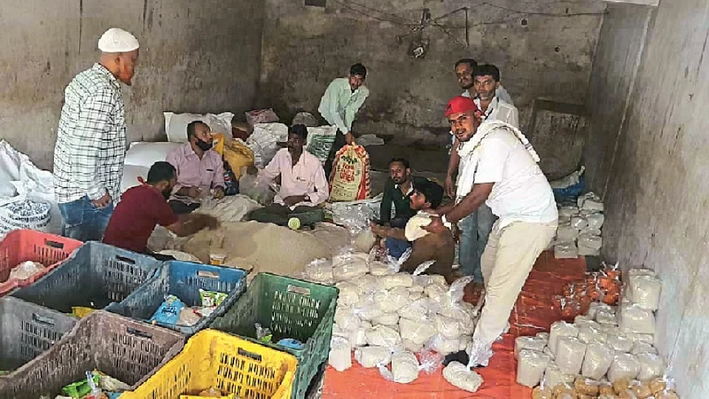 अंबड : शहरात गरजूंना वाटप करण्यात येणाऱ्या साहित्याची बांधणी करताना.