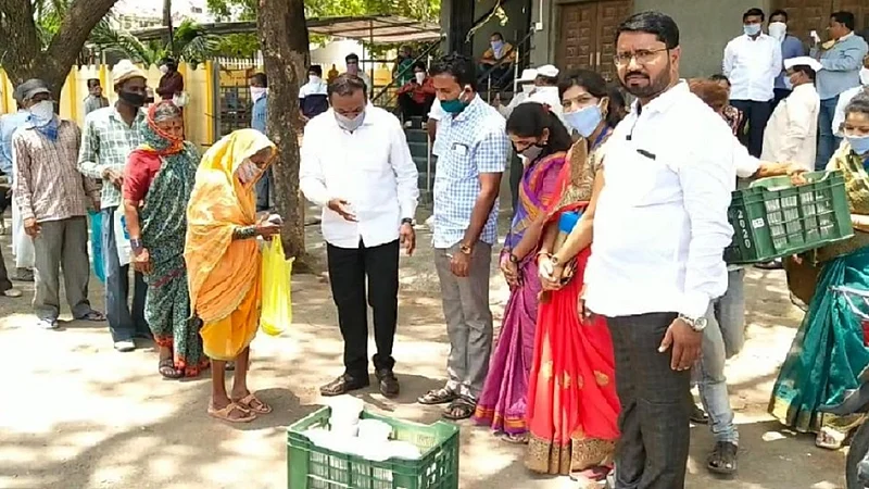 वडगाव मावळ - शहरातील गोरगरीब नागरिकांना जेवणाच्या डब्यांचे वाटप करताना मान्यवर.