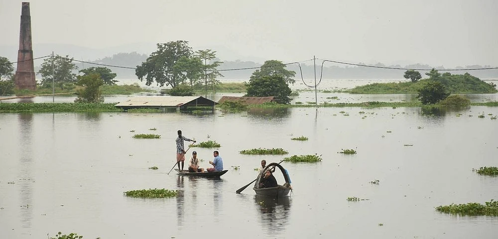 People move to a safer place from a flood-affected area on a boat in the Kamrup District of Assam