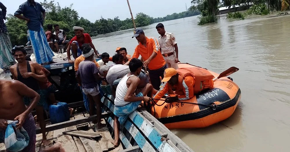 NDRF personnel rescue the residents using boats from the flood-affected area of Morigaon