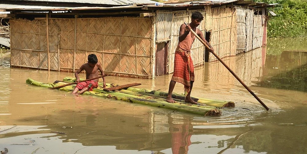 People using Banana raft move to a safer place on a boat from a flood-affected area, at Panikhaiti in Kamrup district of Assam