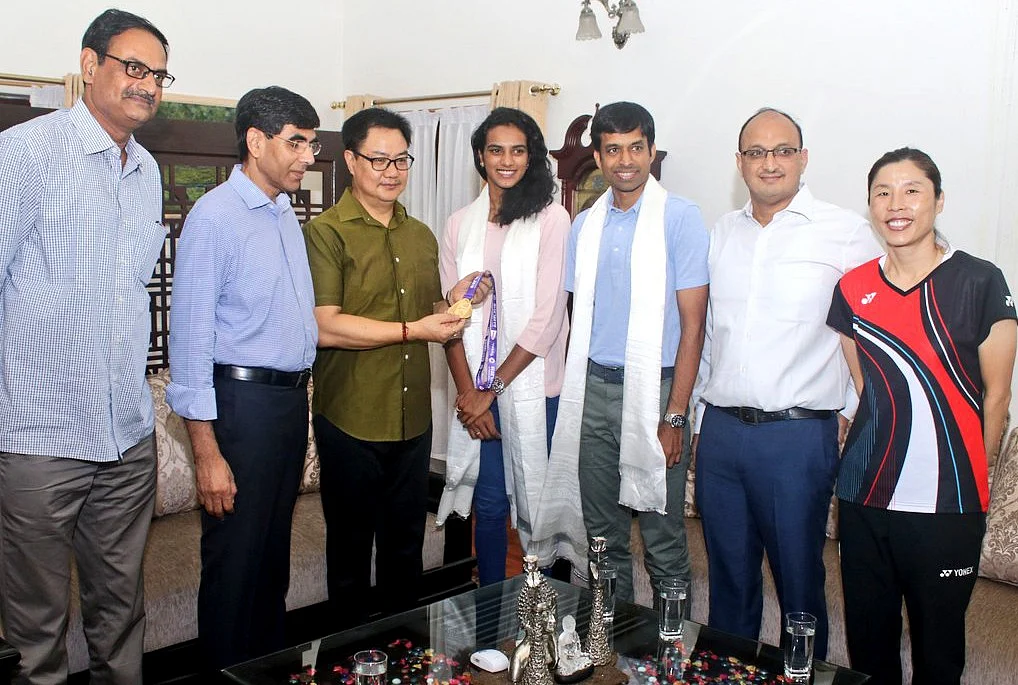Union Sports Minister Kiren Rijiju meets Badminton Player PV Sindhu after winning a gold medal at the BWF World Championships, at his residence in New Delhi, Chief national badminton coach Pullela Gopichand also present