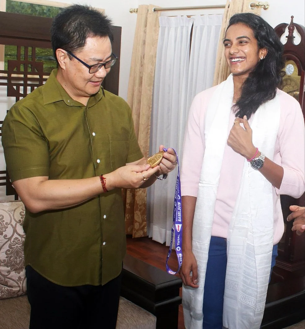Union Sports Minister Kiren Rijiju meets Badminton Player PV Sindhu after winning a gold medal at the BWF World Championships, at his residence in New Delhi