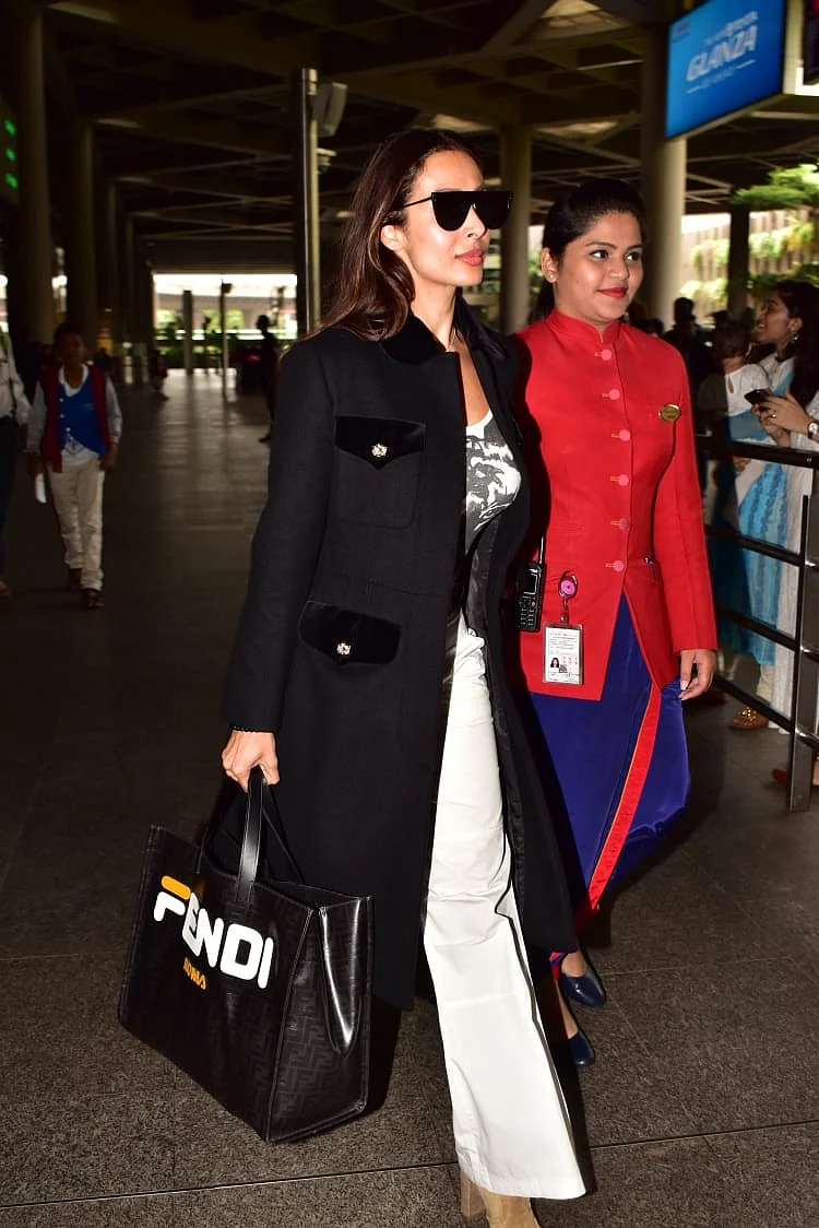 Malaika was spotted with a Fendi bag and a full length jacket with a white bell bottoms and a white t-shirt.